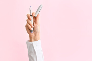 Female hand with syringe for insulin injection on color background. Diabetes concept