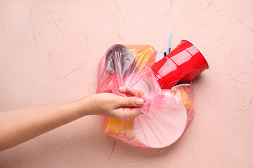 Female hand with plastic garbage on color background. Ecology concept