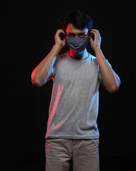 Young men in empty gray T-shirts and wearing health masks, dress up and pose like famous T-shirt models. Men's t-shirt template and mockup design for print.