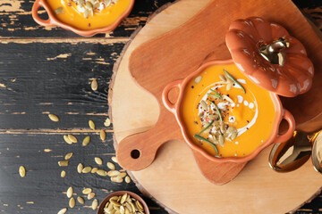 Tasty pumpkin cream soup in pot on table