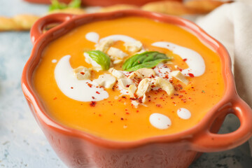 Tasty pumpkin cream soup in pot, closeup