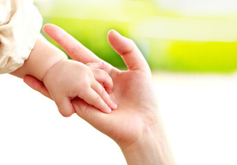 母親と赤ちゃんが手をつなぐ　親子の触れ合い