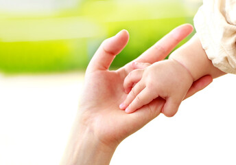 母親と赤ちゃんが手をつなぐ　親子の触れ合い