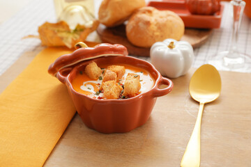 Tasty pumpkin cream soup in pot on table