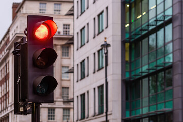 Red traffic lights for cars on a blurred buildings background
