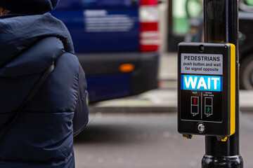 London, England, UK - January 2, 2020: Crosswalk button for pedestrian with light warning on a defocused background , London, UK