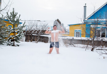 fat guy bathes in the snow in winter