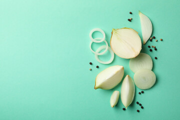 Fresh onion and peppercorns on mint background, top view