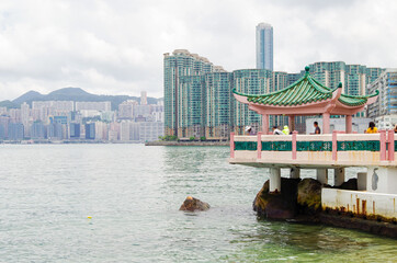 People fishing in Victoria Harbor with view of skyline of Quarry Bay in Hong Kong, China