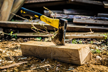 Fototapeta premium Man chopping wood with an ax, close-up, ax in a deck, soft focus
