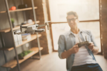 Portrait of his he blurred nice attractive cheerful guy geek skilled expert controlling drone trial...