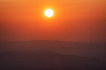 Beautiful big sunset over sea. Tranquil scene of Closeup red sun and red sky sunset