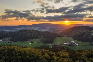 Fototapeta na wymiar Bild einer Luftaufnahme mit einer Drohne der Stadt Grafenau im bayerischen Wald mit Bergen Arber Rachel und Lusen im Hintergrund während des Sonnenuntergang, Deutschland