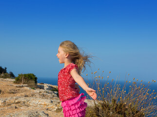 blue day with kid girl open hands to the wind