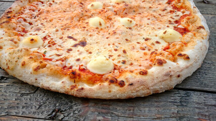 pizza margherita entière sur une table en bois