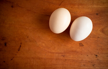 Two fresh white eggs put naturally on a wooden table
木製テーブルの上に自然に置かれた二つの新鮮な白い卵