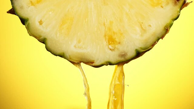Super Slow Motion of Water Splash on Fresh Backlit Pineapple Slice. Shot at 1000 fps.