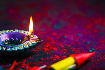 Diwali Diya with Fire Crackers over rangoli background
