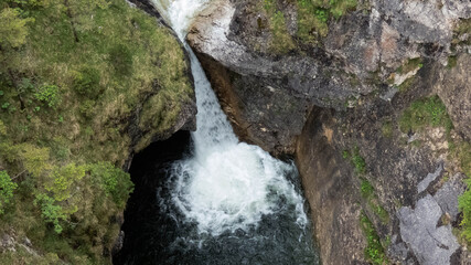 small waterfall with dark blue water