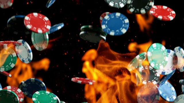 Poker chips with fire flames falling on casino table in super slow motion, filmed on high speed cinema camera at 1000 fps. Gambling background.