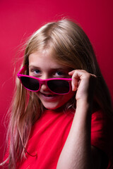 Fototapeta premium Portrait of a young girl on red background
