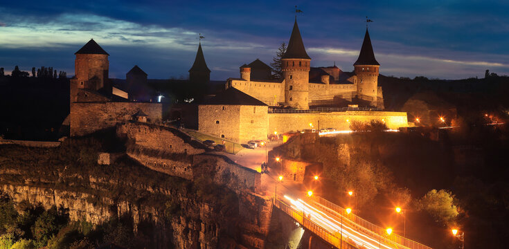 Panoramic  night view of ancient fortress castle in Kamianets-Podilskyi, Khmelnytskyi Region, Ukraine. Old ?astle photo on a postcard or cover. Long exposive