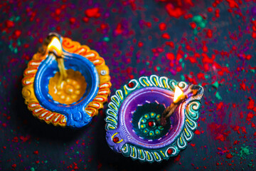 Fototapeta premium Diwali Diya with Fire Crackers over rangoli background