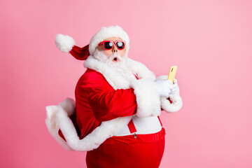Profile side photo of shocked grey bearded santa claus use smartphone impressed x-mas tradition...