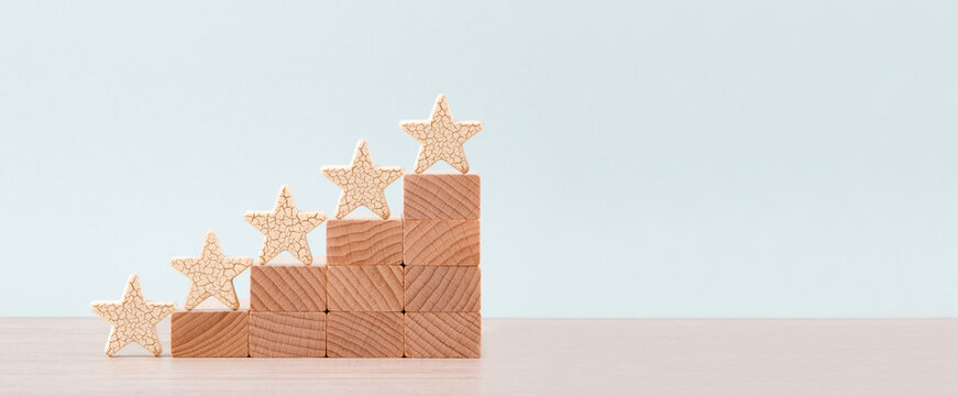 Wooden five star shape on table. Concept of increase rating, ranking, evaluation and classification idea.