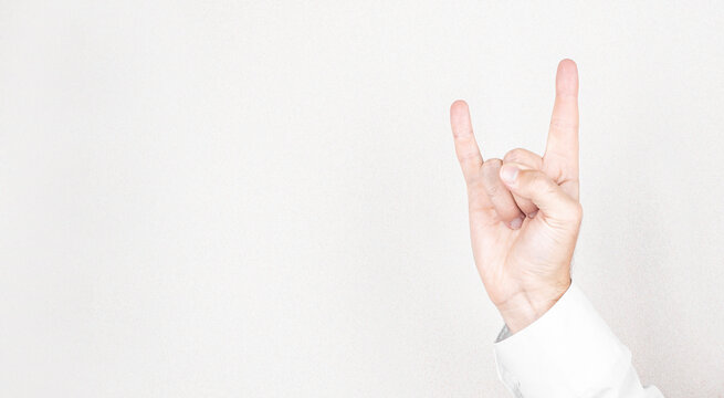 Male hand close-up on a white background shows hand gesture. Rock'n'roll. Isolate.