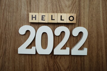 Hello 2022 word alphabet letters on wooden background