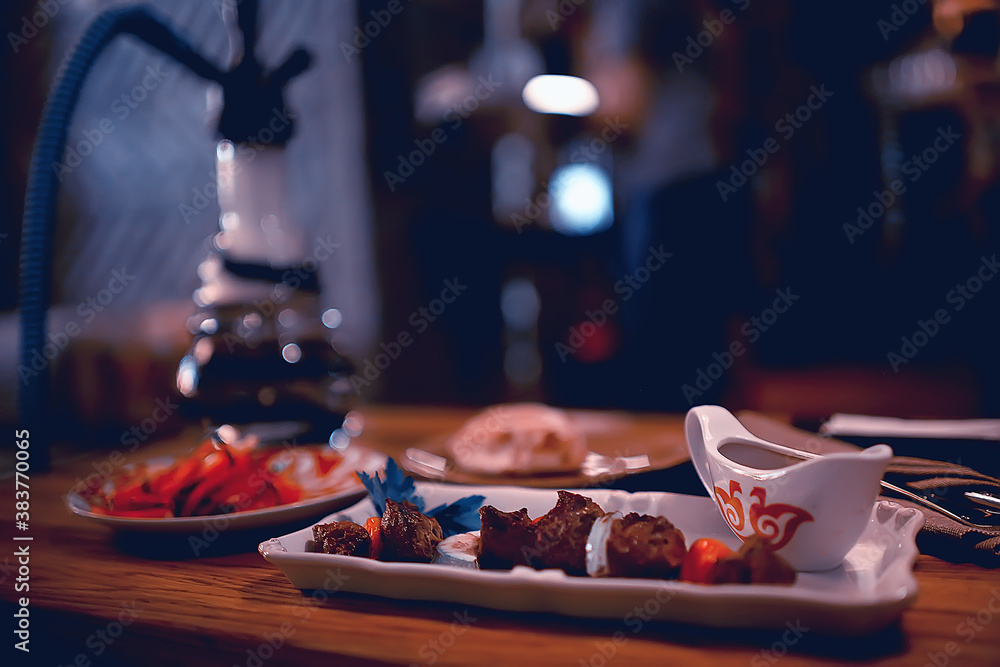 Wall mural steak in the restaurant on the table / dinner in the restaurant, meat on the plate, served steak and cutlery