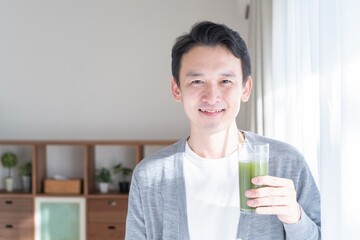 野菜ジュースを飲むアジア人男性