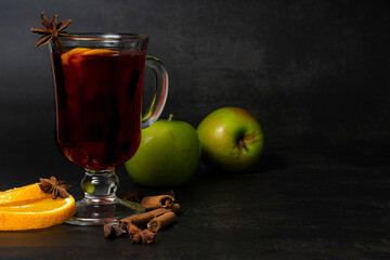 selective focus, hot drink, warmed red wine with fruit from oranges and apples, with spices of anise and cinnamon
