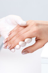 Female hand after manicure in hand of manicure master at nail salon