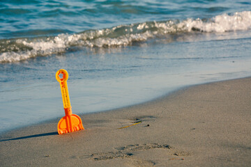 Toy Spade at the Beach With Waves in the Background