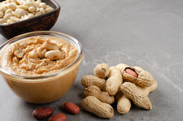 Low angle view at glass bowl with peanut butter on stone table. Healthy eating concept