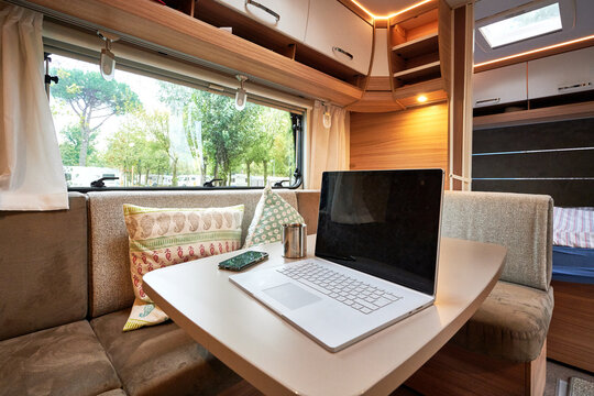 Homeoffice Arbeiten im Wohnwagen Wohnmobil mit Laptop und Internet im Urlaub auf dem Campinglatz 
