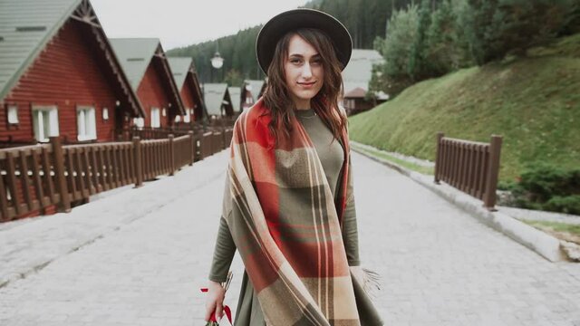 hipster girl in a green hat and cloak walks the streets of Switzerland.Woman In Hat Enjoying Sun