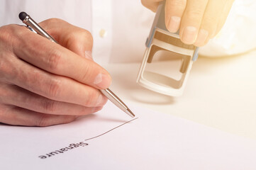 Stamping and signing document close up, male hands over space for signature