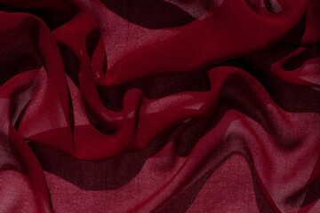 Smooth elegant burgundy chiffon fabric abstract background. Dark red wine silk satin luxury cloth...