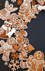 Christmas gingerbread cookies with icing and confectionery mastic snowflakes on black background, view from above. Holiday food, homemade baking, Christmas and New Year traditions. - 383776614