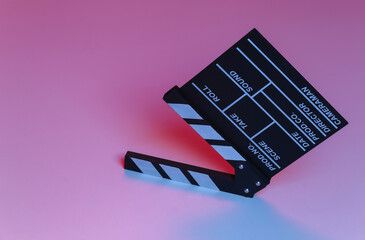 Film clapper board in blue red neon light. Cinema industry, entertainment