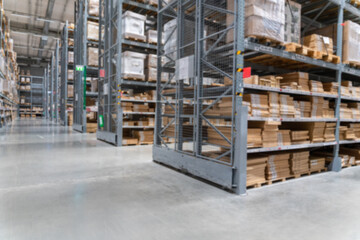blurred background image of Rows of shelves with goods boxes in modern industry warehouse store at...