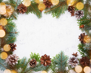 Fototapeta na wymiar Christmas and Happy New Year light white background. Frame with garland lights, fir branches, berry, cones. Stone backdrop with copy space.