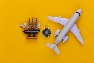 Minimalism travel, adventure flat lay. Compass and ship, air plane on yellow background. Top view
