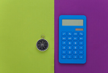 Calculator and compass on purple green background. Business concept. Top view