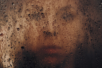 portrait of a girl behind wet glass
