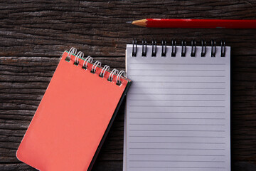 memo note pad and red colored pencil on wood background.
