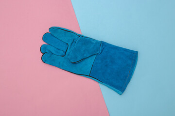 Work glove on a blue-pink pastel background. Top view
